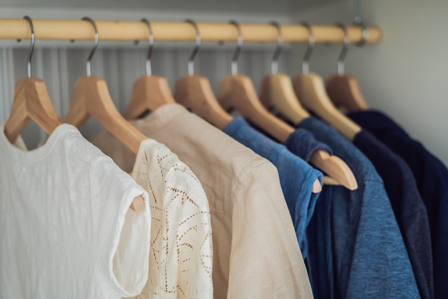 Clothes on hangers in the cabinet gradient from white to dark blue